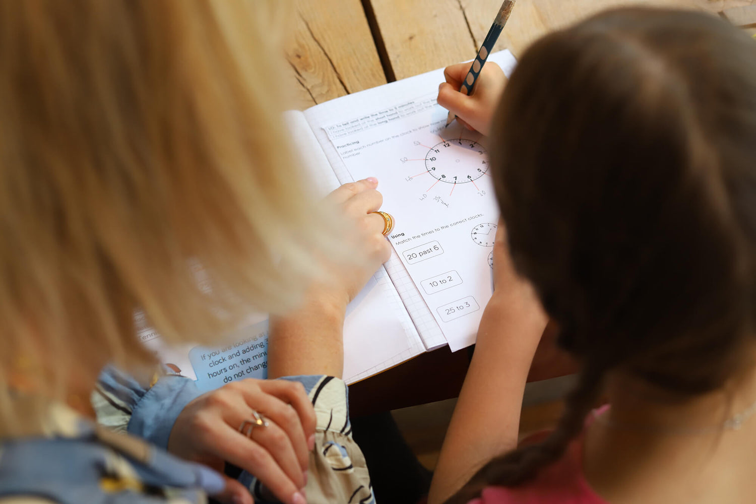 Female student and tutor annotating an image of a clock face